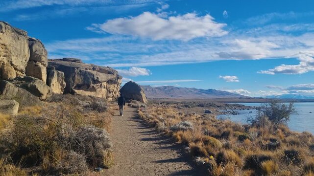 Stunning Patagonian landscape with a man walking along glacial Lago Argentino at Punta Walichu near El Calafate, Argentina, scenic wilderness, golden evening light and pristine nature