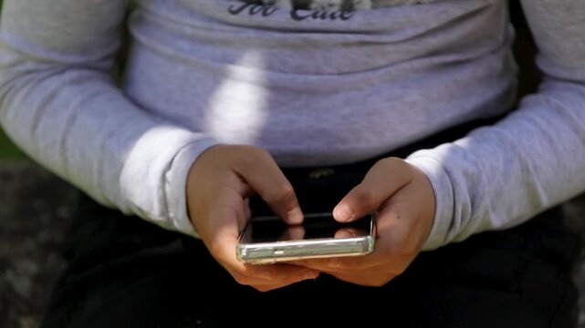 child's hands typing and chatting on a smartphone,  the risks of online communication, and the importance of child safety and online parental control