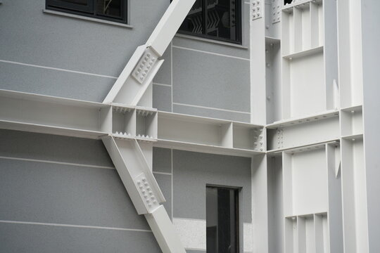 A detailed white steel seismic brace is mounted on building.