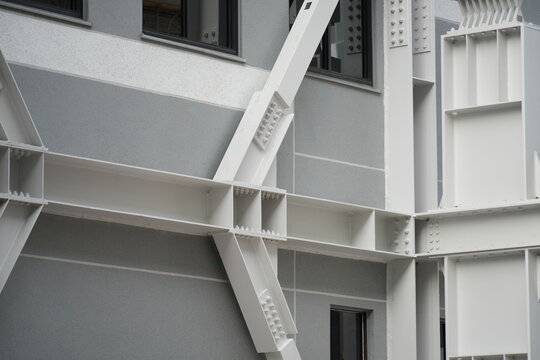 A detailed white steel seismic brace is mounted on building.