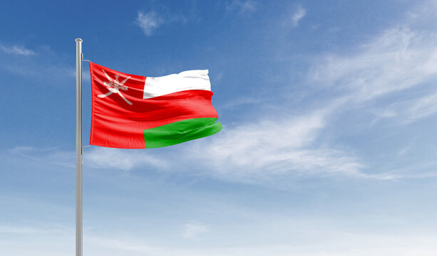 Oman national flag waving in the sky.