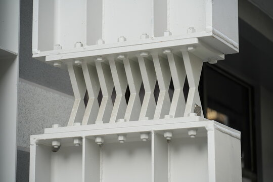 A steel seismic damper is installed on a modern building structure.
