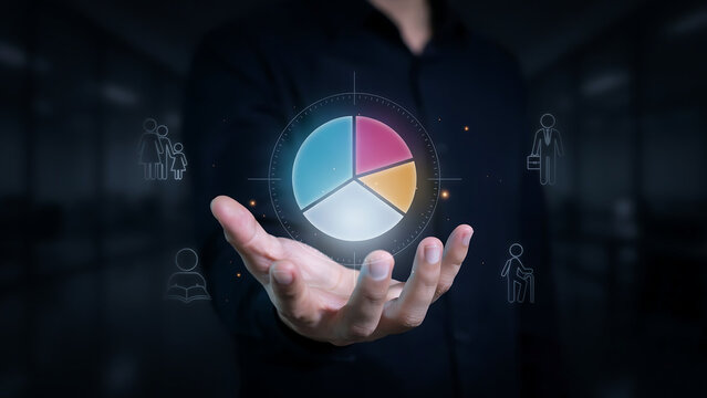 Open hand holding glowing colorful pie chart graph surrounded by demographic customer icons for target market audience segment analytics