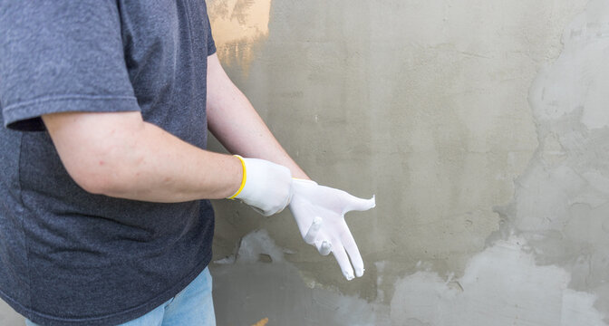 Worker puts on white gloves before concrete work