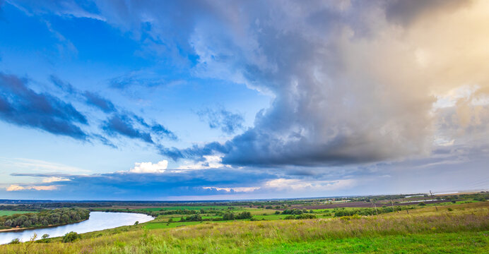 Vast green fields stretch toward a winding river