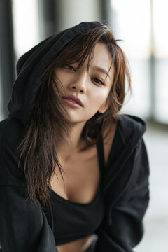Nahaufnahme eines asiatischen Frauenportr&auml;ts mit dunklem Pony und schwarzem Rollkragenpullover. Ausdrucksstarke Beauty-Fotografie, nat&uuml;rliche Sch&ouml;nh