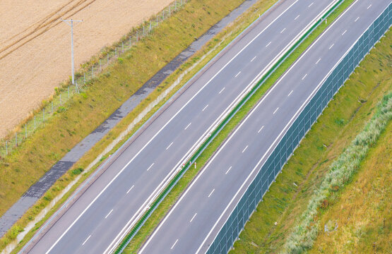 Aerial view of Droga Ekspresowa S6 highway with sound barriers and adjacent agricultural fields in Slupsk, Pomeranian Voivodeship, Poland.