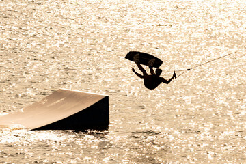 Wassersport - Sportler springt beim Wakeboarden über Schanze  © Christina Pichler