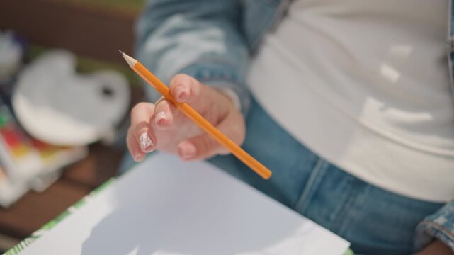 Anticipation builds as artist readies pen and paper. Eager artist prepares to make first mark on blank page. Moment of artistic anticipation as hands poised for initial creative stroke