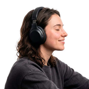 Young woman with dark curly hair wearing black over ear headphones and a grey sweatshirt with eyes closed smiling PNG Isolated on transparent background