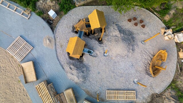 A newly built wooden children&rsquo;s playground in a modern residential neighbourhood, aerial drone top down.