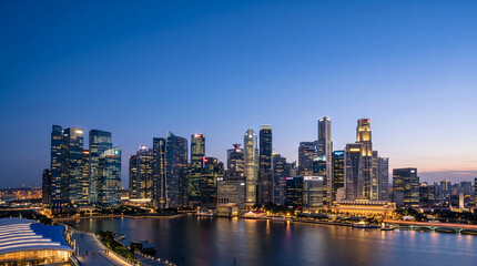 Naklejka premium Singapore skyline with illuminated skyscrapers reflects in Marina Bay at twilight