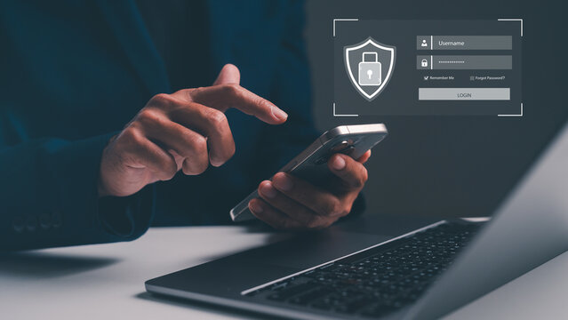 A person uses a smartphone with a laptop nearby, highlighting a secure login interface emphasizing cybersecurity and data protection.