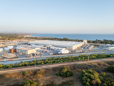 Aerial view of hyperscale data center industrial facility near the coast with storage tanks and surrounding infrastructure in Sines, Setubal, Portugal.