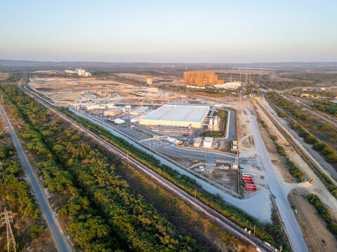 Aerial view of hyperscale data center and industrial facility and power plant complex surrounded by roads, railway tracks, and green vegetation in Sines, Setubal, Portugal.