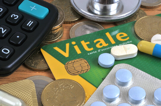Vannes, France, 31 juillet 2026 : Concept de mutuelle sant&eacute; avec une carte Vitale de l'argent en euros,des blisters de m&eacute;dicaments, une calculatrice et un st&eacute;thoscope