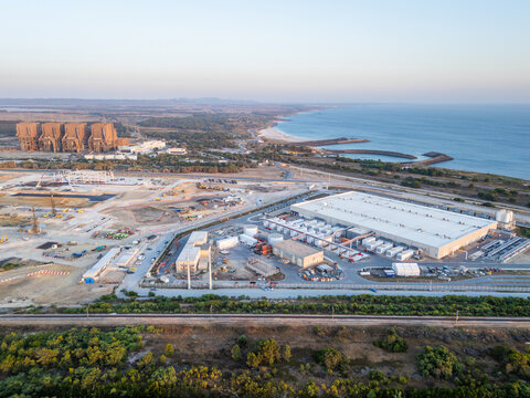 Aerial view of hyperscale data center, industrial area in Sines, featuring a large power plant facility, construction site, and modern warehouse on coastline of Sines, Setubal, Portugal.