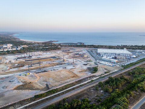 Aerial view of hyperscale data center and a large industrial construction site with heavy machinery, cranes, and earthworks located near the coastline in Sines, Setubal, Portugal.