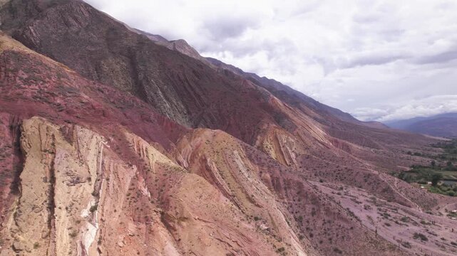 4K drone aerial view of Paleta del Pintor in Maimar&aacute;, Jujuy, Argentina. Iconic colorful mountain landscape in the Quebrada de Humahuaca, with vibrant geological layers shaped by erosion.