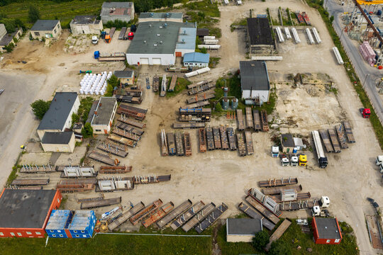 Aerial view of an industrial logistics yard filled with numerous flatbed trailers and trucks parked near warehouses in Vilnius, Vilnius County, Lithuania.