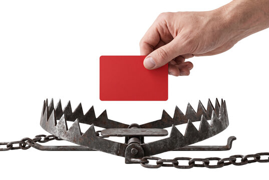 Hand holding a credit card above a metal animal trap