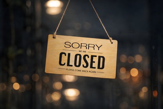 sorry we are closed sign hanging outside a restaurant, store, office or other. Closed sign in a shop showroom with reflections bokeh.