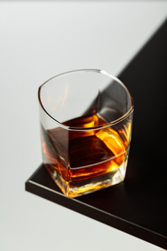 Glass of whiskey on a black table.
