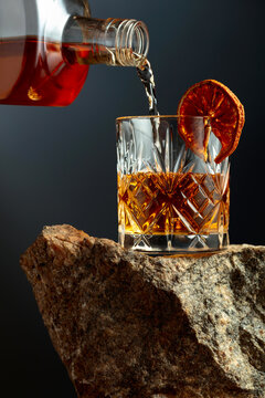 Old-fashoned cocktail on a rough granite.