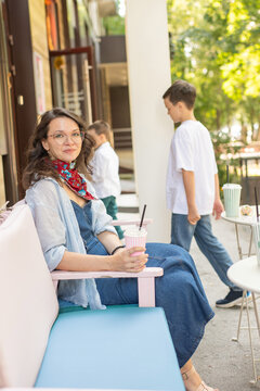 A Caucasian woman with her two sons and a cat in a cafe. Pet-friendly outdoor cafe.