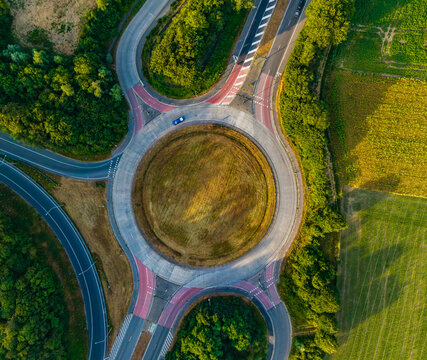 Aerial view of CCB Granulats Gaurain roundabout surrounded by lush green trees and agricultural fields in Tournai, Wallonia, Belgium.