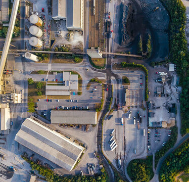 Aerial view of CCB Granulats Gaurain industrial site featuring storage silos, warehouses, parking lots, and heavy machinery in Tournai, Wallonia, Belgium.