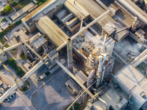 Aerial view of CCB Granulats Gaurain industrial facility featuring complex piping systems, tall chimneys, and large factory rooftops in Tournai, Wallonia, Belgium.