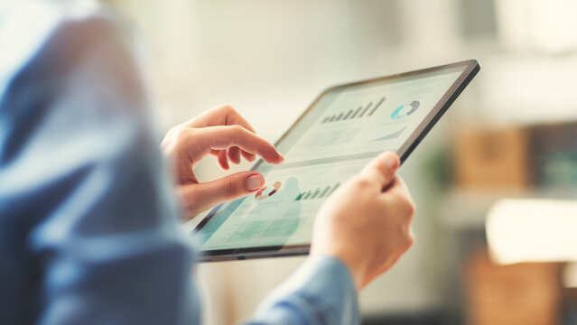 Analyzing business reports displayed on a digital tablet screen