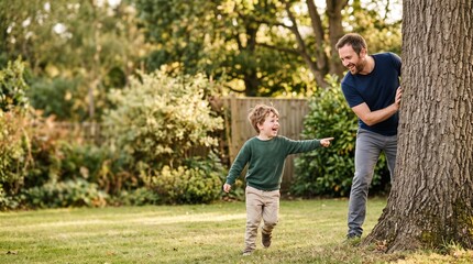 Fototapeta premium Father and son playing hide and seek in a sunny garden with lush green trees and grass