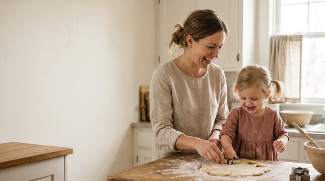 Mother and daughter happily baking cookies together in a bright kitchen, making memories