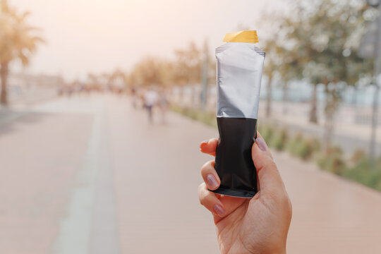 Person holding energy or protein gel drink, ready for a quick snack during outdoor activities