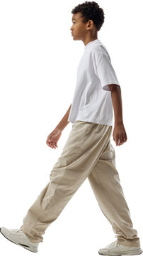 Boy walking left in profile isolated on transparent background. Concept of directional layouts, casual clothing catalogs, public space visualization.
