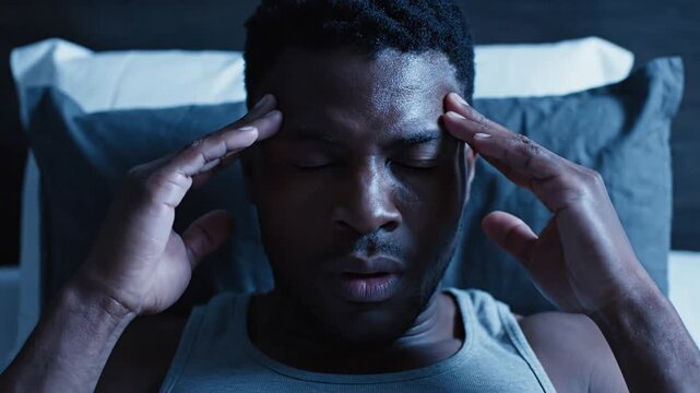Man With Migraine In Bed At Night Suffering From Insomnia Headache