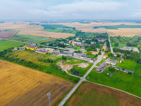 Aerial view of the rural village of Jaunberze surrounded by agricultural fields, roads, and residential buildings in Jaunberze, Dobele Municipality, Latvia.