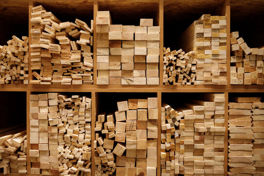 Wooden planks and timber studs stacked in cells on shelves inside hardware home improvement store background raw lumber material row warehouse retail construction market texture nobody