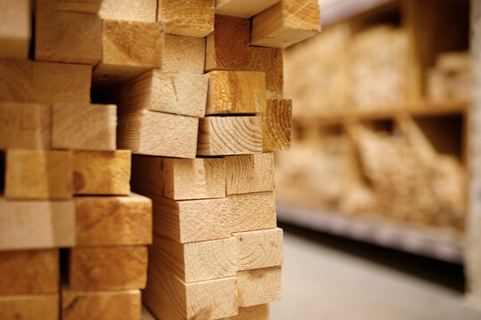Wooden planks and timber studs stacked in cells on shelves inside hardware home improvement store background raw lumber material row warehouse retail construction market texture nobody