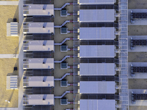 Aerial view of a data center with rows of modular server units, cooling systems, and connecting pipes in Illinois, United States.