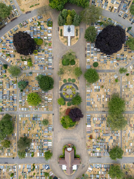 Aerial view of Gunnersbury Cemetery showing rows of gravestones, manicured pathways, mature trees, and a central chapel building in London, England, United Kingdom.