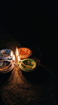 Happy Diwali - Colorful Clay Diya lit during Deepavali festival, selective focus