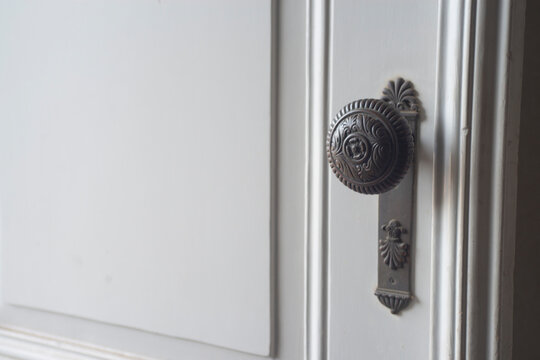 Old vintage door handle on white door