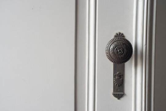 Old vintage door handle on white door