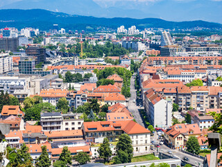 Obraz premium Overview of Ljubljana showing rooftops and buildings surrounded by mountains