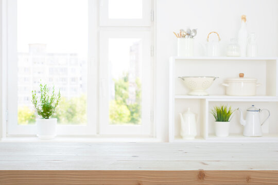 Wood table top for products display montage on blurred kitchen window and shelf background