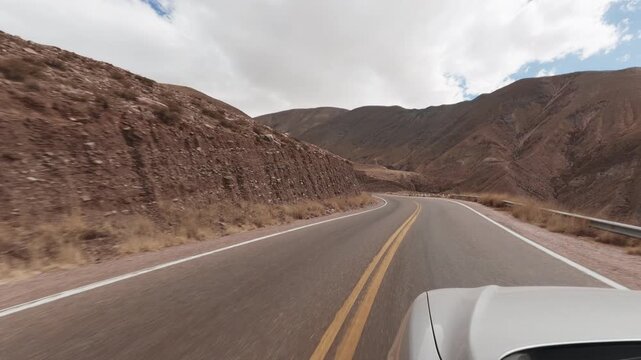 Driving POV on scenic National Route 68 in Quebrada de las Conchas Salta Argentina. Mountains, red. Hood reference.