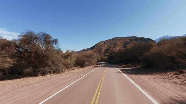 Driving POV on scenic National Route 68 in Quebrada de las Conchas Salta Argentina. Mountains, red. Hood reference.